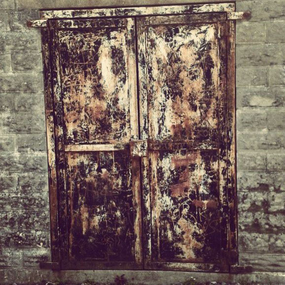 closed rusty doors in a brick wall