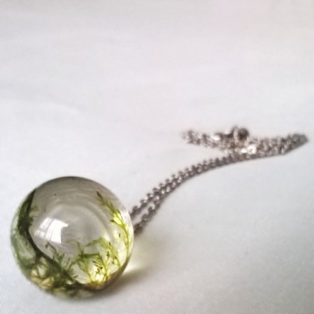 moss trapped within a glass sphere as a necklace