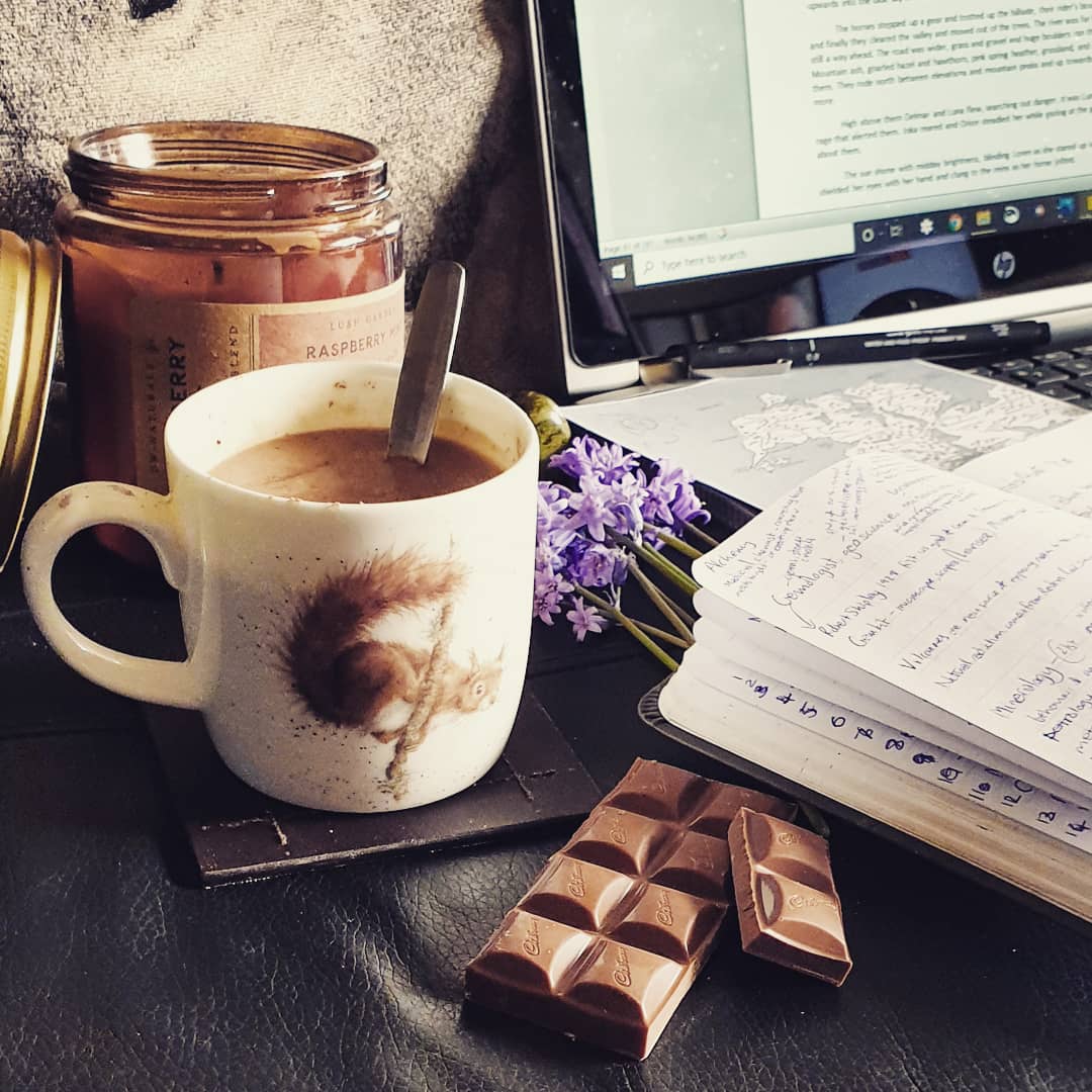 my writing tools - hot chocolate, scented candle, bluebells, chocolate, notebook, laptop